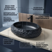 Black artificial stone oval table top wash basin 600x400x150 mm with rough natural rock textured exterior and smooth black interior, luxury designer countertop bathroom sink with modern styling and product dimensions.