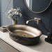 Black and champagne gold royal floral oval table top wash basin 580x370x150 mm featuring matte black exterior, metallic gold interior, antique gold ornamental scrollwork and scalloped rim for luxury bathroom countertops.