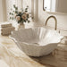 White seashell design table top wash basin 470x390x170 mm featuring elegant scalloped wavy edges, vertically ribbed shell texture and natural speckled finish, luxury designer countertop bathroom sink for modern bathrooms.