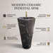 Black marble-effect ceramic pedestal wash basin with tapered freestanding design, integrated bowl and 390 × 390 × 820 mm size for modern luxury bathrooms.