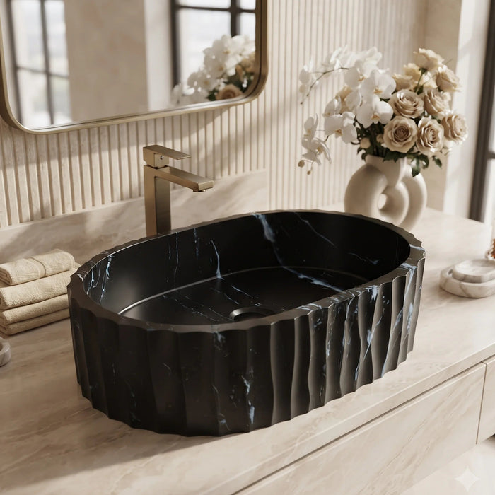 Black marble finish oval table top wash basin with white veining, sculpted vertical fluted exterior and 20 inch countertop design for modern luxury bathrooms.