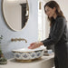 Blue and gold floral design oval table top wash basin 560x385x150 mm featuring glossy white interior, intricate ornamental blue patterns, elegant gold rim and base accents, luxury designer countertop bathroom sink.