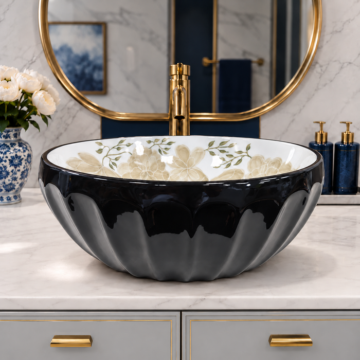 Glossy black round tabletop wash basin with a scalloped exterior and beige floral design on a white interior.