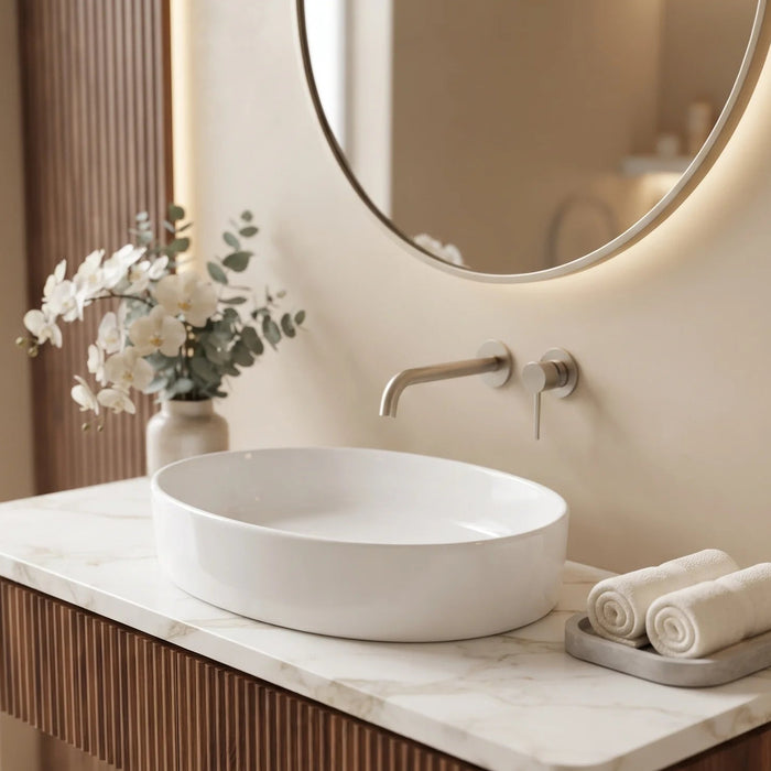 Glossy white oval table top wash basin measuring 550 × 410 × 140 mm, with a smooth curved bowl, styled on a bathroom vanity counter.