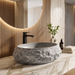 Grey artificial stone table top wash basin with matte speckled interior, oval shape and natural rock-textured exterior, 560 × 480 × 135 mm.