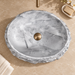 Grey oval artificial stone tabletop wash basin with a matte finish, rugged textured exterior and smooth patterned interior, measuring 500 × 400 × 150 mm.