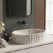 Ivory white marble finish oval table top wash basin with beige veining, vertical fluted exterior and 20 inch countertop design for modern luxury bathrooms.