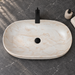 Oval ceramic table top wash basin with a matte cream and beige marble-pattern finish, measuring 675 × 350 × 140 mm.