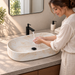 Oval ceramic table top wash basin with a matte cream and beige marble-pattern finish, measuring 675 × 350 × 140 mm.