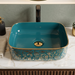 Teal blue and gold rectangular table top wash basin 400 × 300 × 140 mm with glossy finish and ornate floral pattern, designed for modern luxury bathrooms.