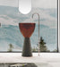A free-standing, transparent resin wash basin with a pedestal base, placed in a room with a scenic view.