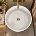 White artificial stone freestanding pedestal wash basin with matte finish, round bowl and elegant vertical wave textured design, 400x400x840 mm for modern luxury bathrooms.
